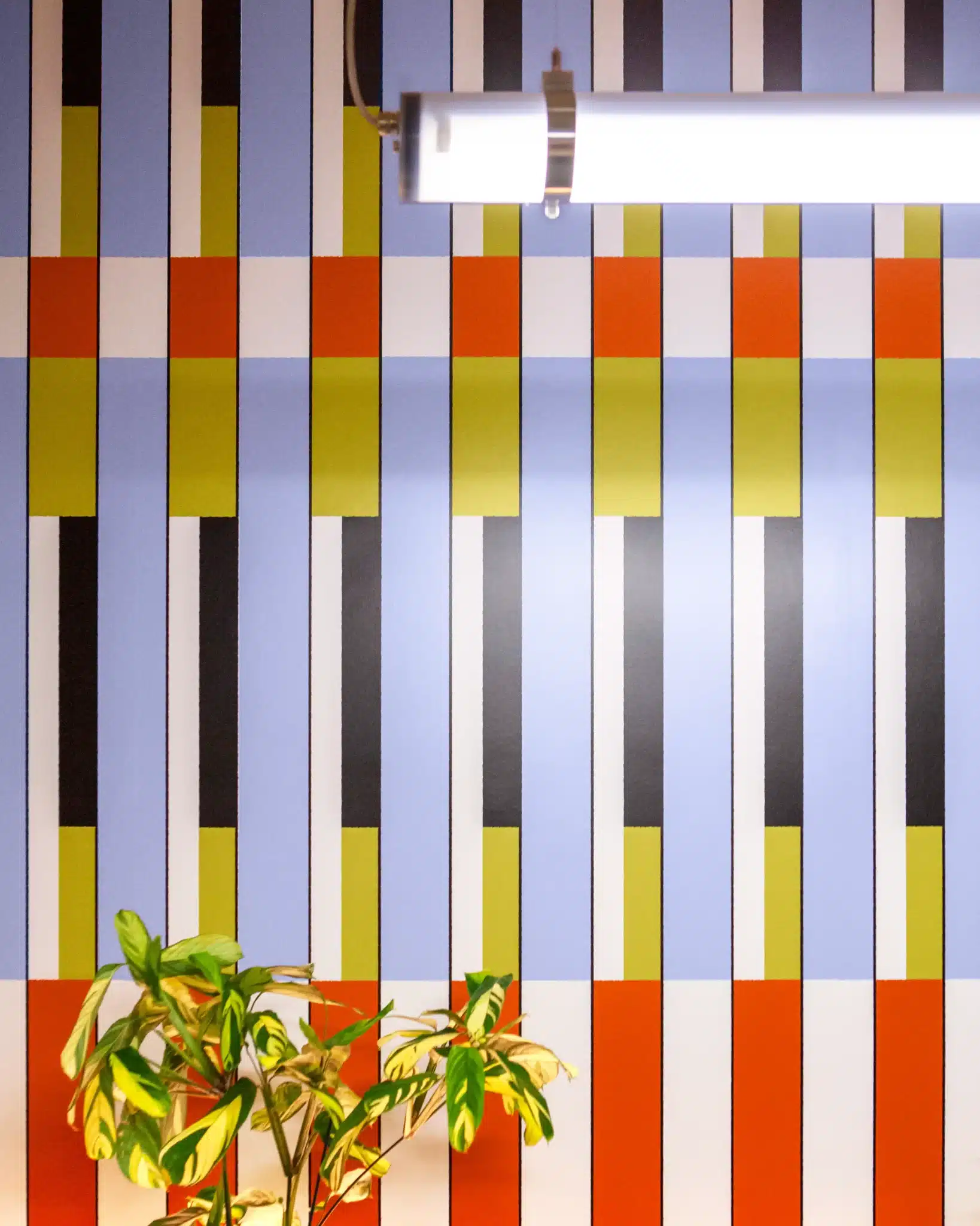 Motif graphique mural aux couleurs orange, jaune et bleu dans le restaurant.