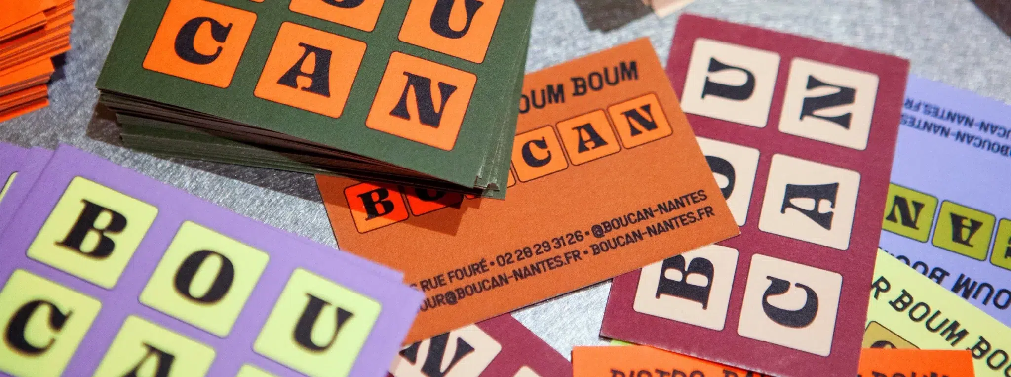 Cartes de visite colorées du restaurant-bar Boucan avec lettres typographiques