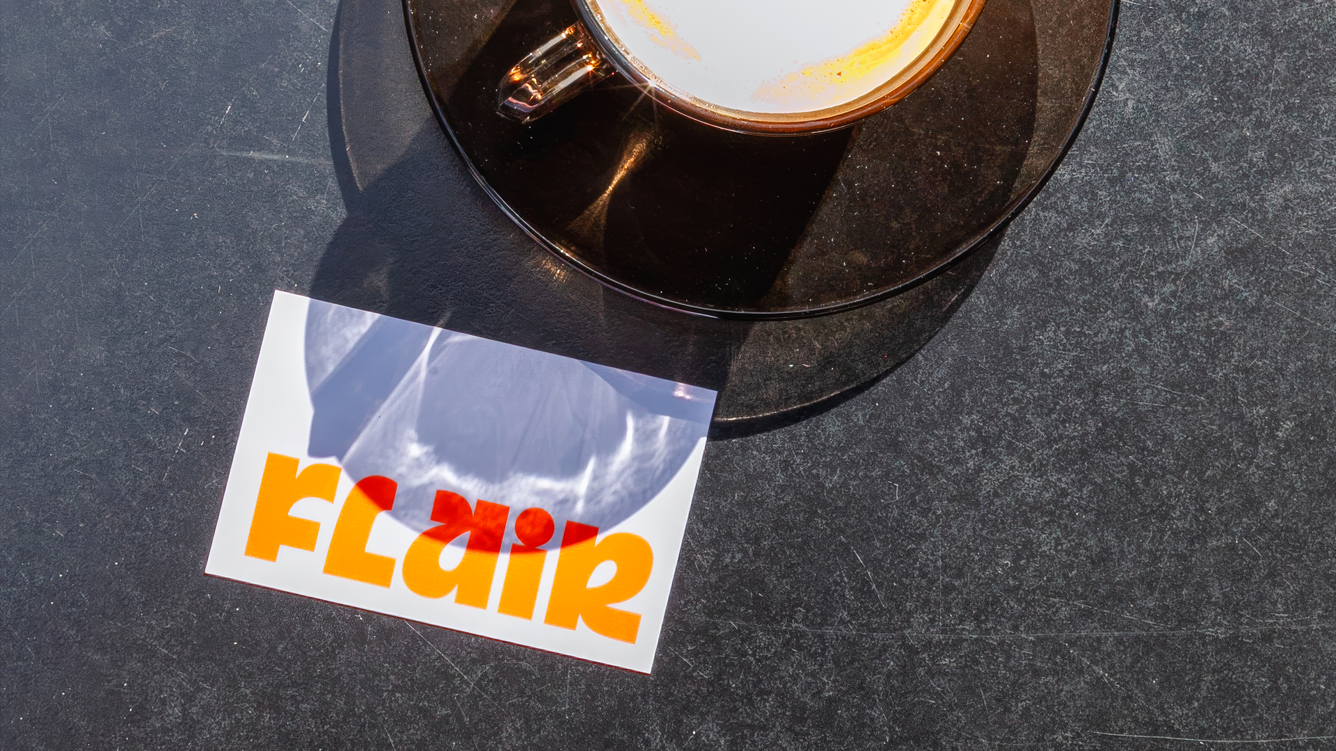 Carte Flair orange posée près d'une tasse de café